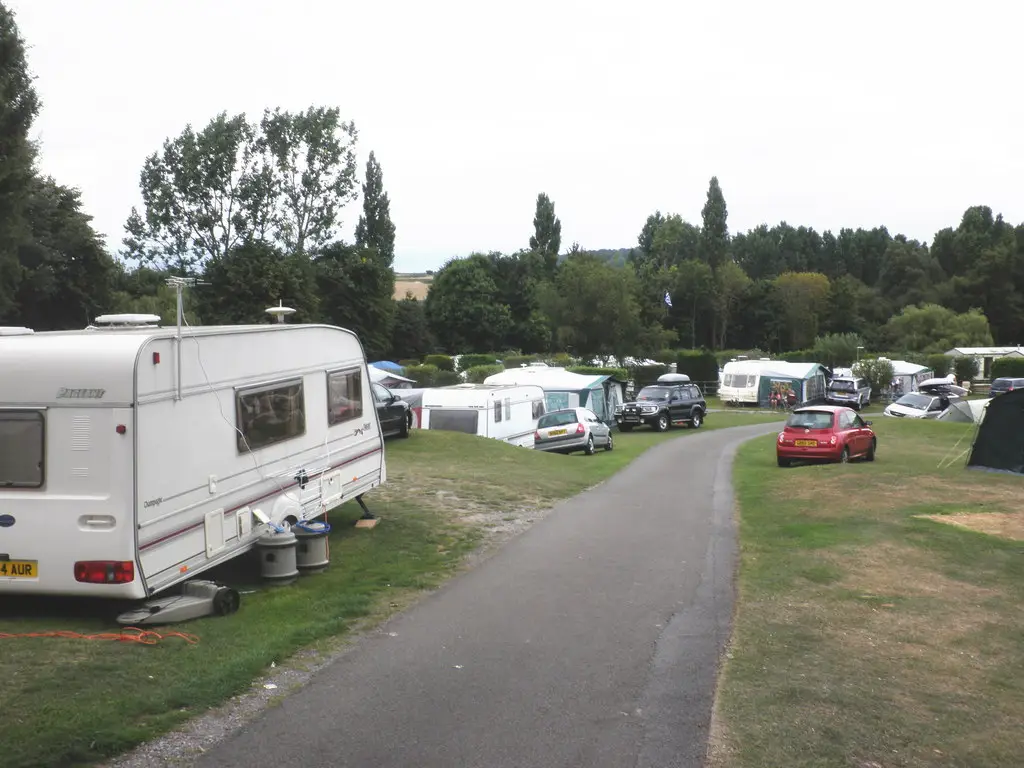 Tenten en caravans op een boerencamping in een weiland