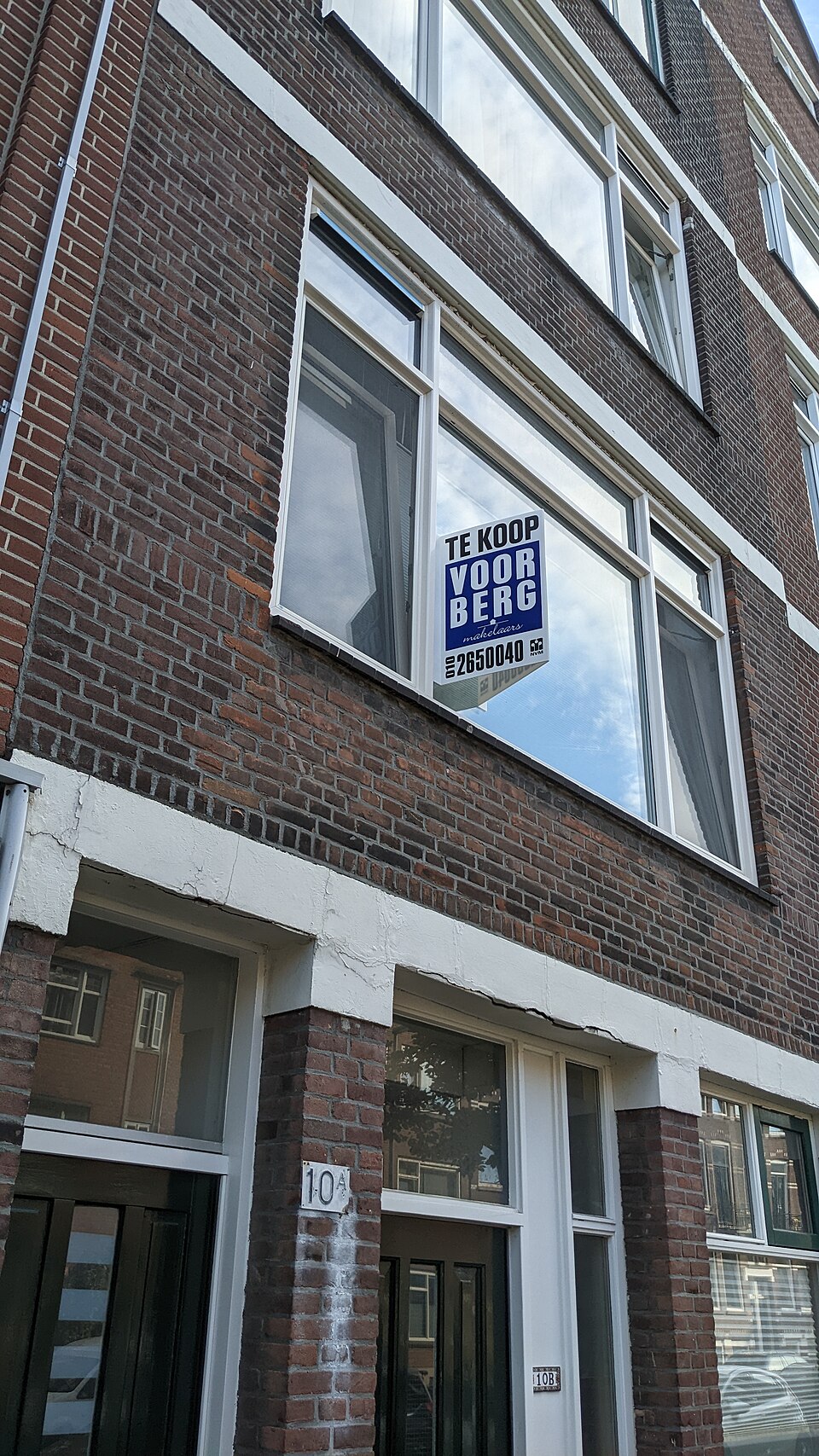 Makelaarsbord bij een woning die te koop staat