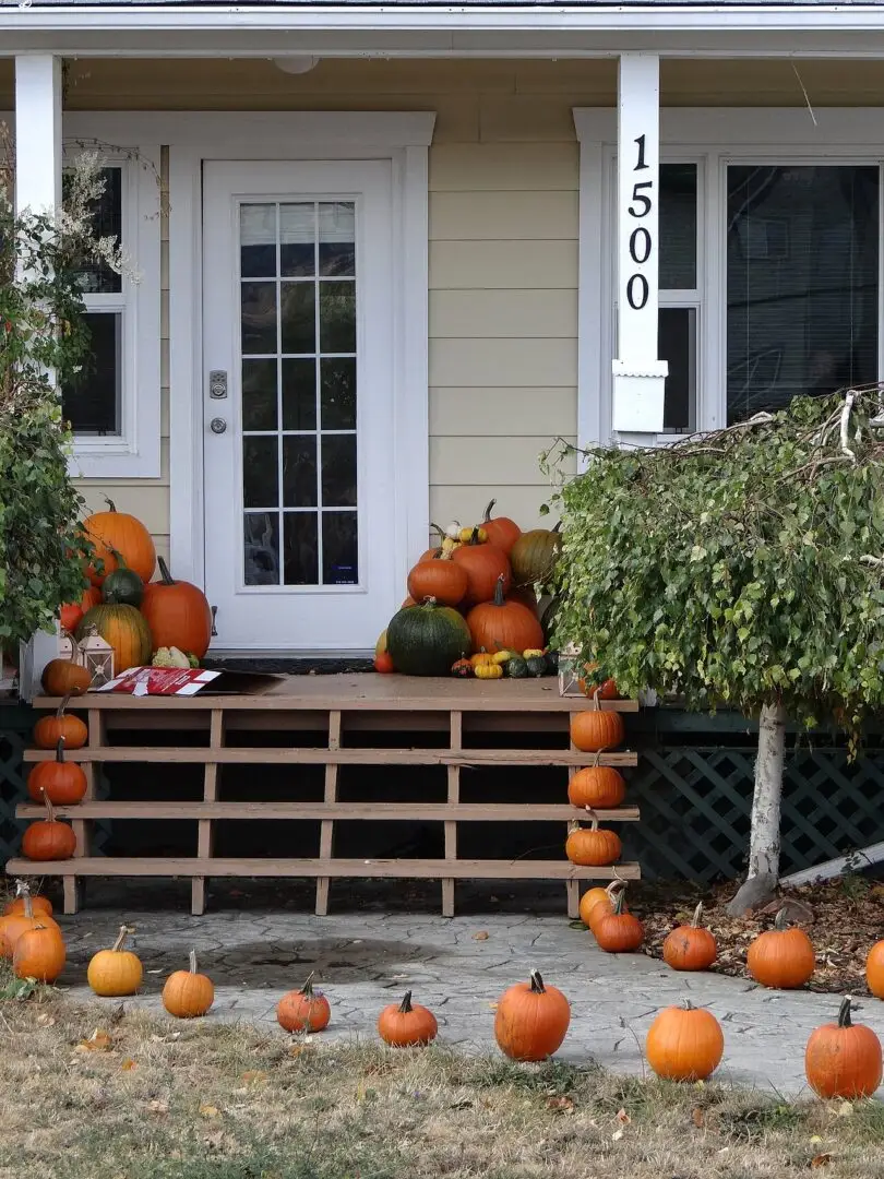 Pompoenen als herfstdecoratie bij een voordeur